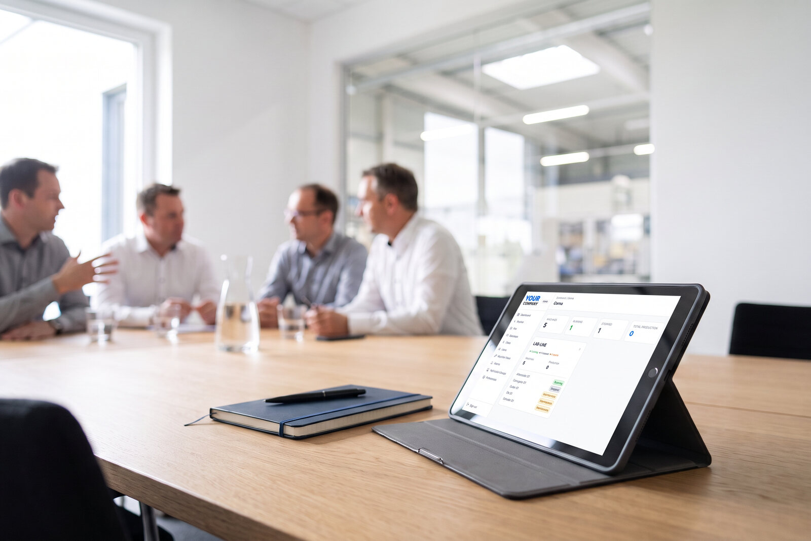 A tablet on a meeting-room table showing the customer dashboard under the customer's own brand, managers out of focus behind. Illustrative photo, demo data.