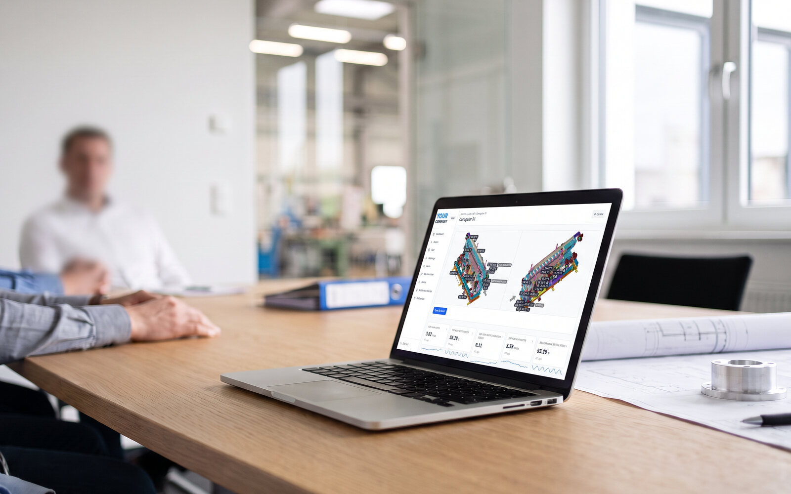 A laptop on a meeting-room table showing a machine page under the customer's own brand, live values pinned on a 3D corrugator model, a technical drawing beside it. Demo data, illustrative photo.